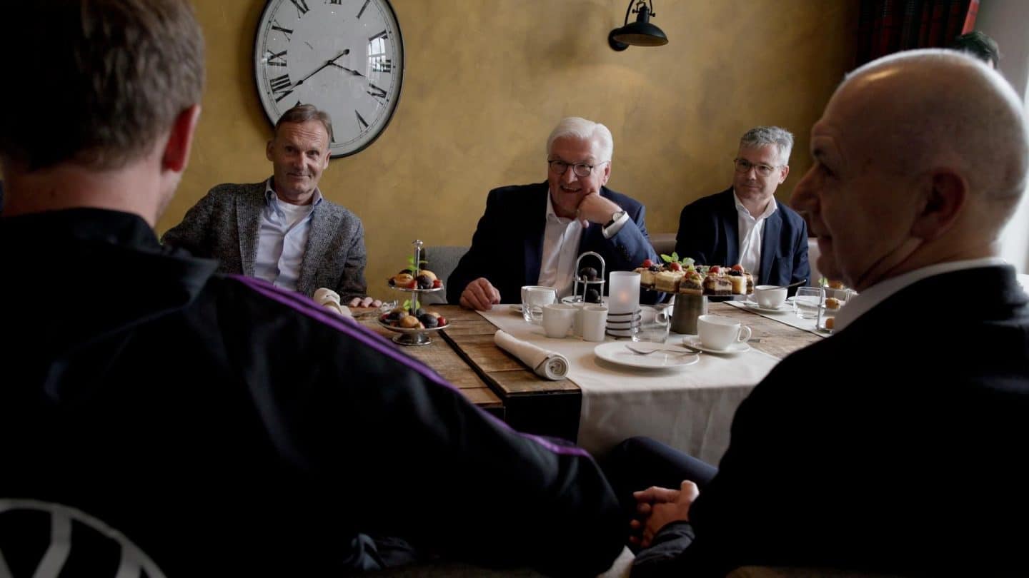 Bundespräsident Frank-Walter Steinmeier im Gespräch mit Hans-Joachim Watzke, dem Geschäftsführer von Borussia Dortmund, während eines Treffens mit Spielern und Verantwortlichen der deutschen Nationalmannschaft. Bei Kaffee und Gebäck diskutieren sie in entspannter Atmosphäre über die Heim-EM 2024.