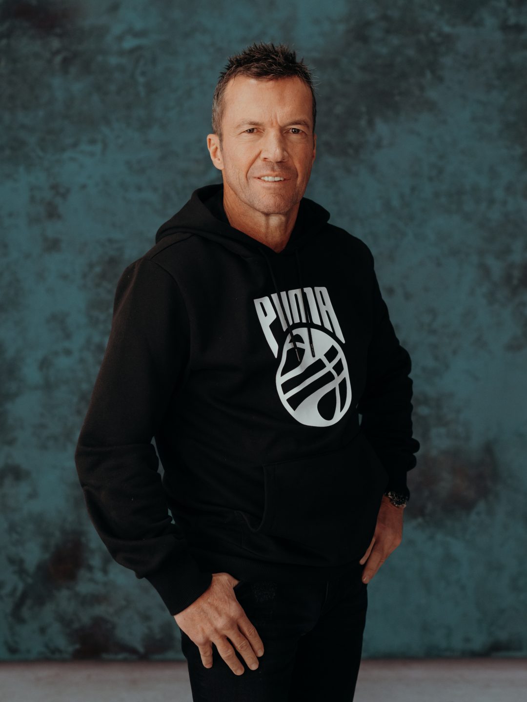 Lothar Matthäus stehend, lächelt in die Kamera.