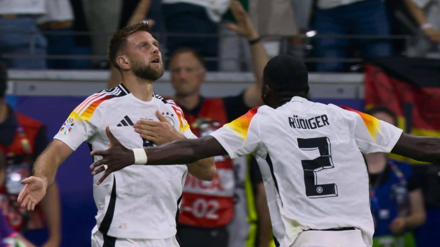 Jubel nach dem Tor: Ein Spieler der deutschen Nationalmannschaft hält sich die Hand aufs Herz, während Antonio Rüdiger ihn feiernd umarmt – ein emotionaler Moment während der Heim-EM 2024