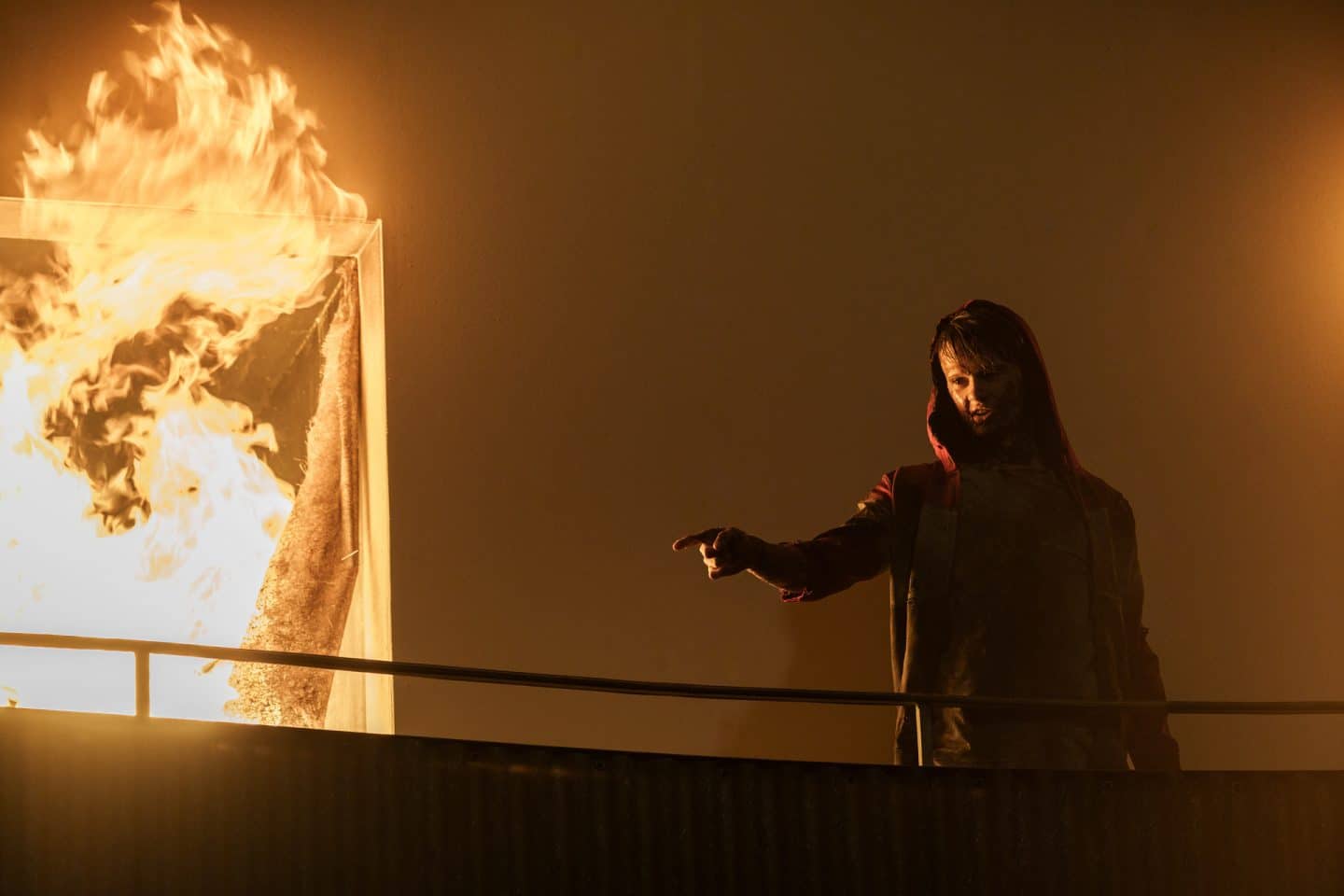 "Hameln - Träume": Damir Vucovic (Aaron Kissiov) steht auf einem Balkon, hinter ihm steigen große Flammen aus einem Fenster. Auch Damir ist vom Feuer gezeichnet.
