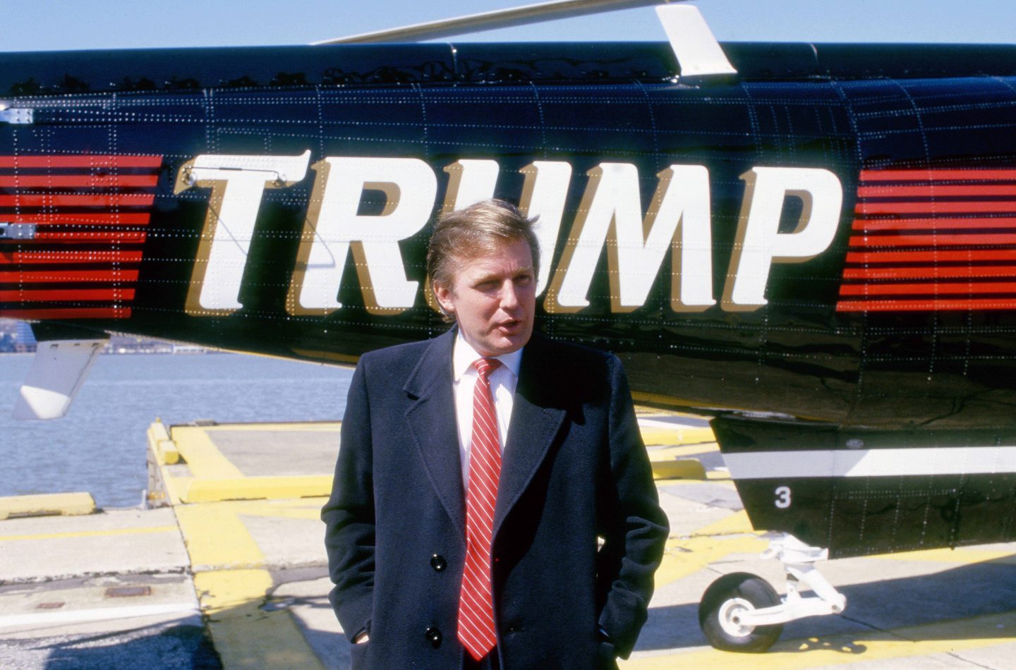 Donald Trump steht vor einem schwarzen Helikopter mit seinem Namen 'TRUMP' darauf, 22. März 1988.