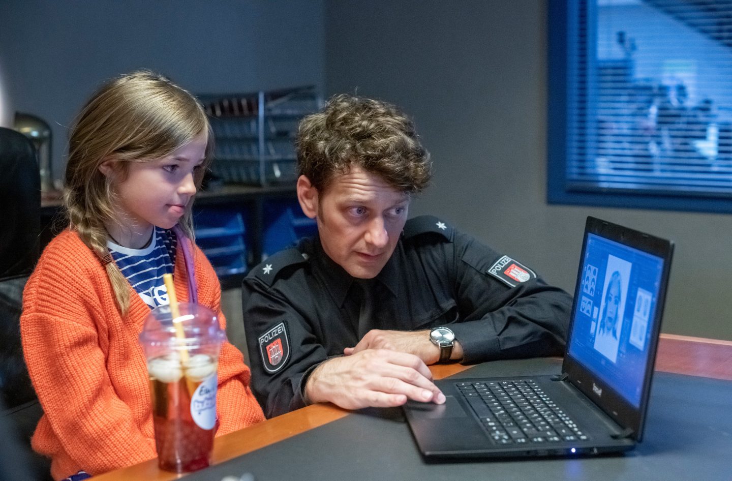 Daniel Schirmer (Sven Fricke, rechts) erstellt an einem Laptop ein Phantombild basierend auf den Beobachtungen von Emilia (Lara Toni Lüdders, links), die aufmerksam daneben sitzt.