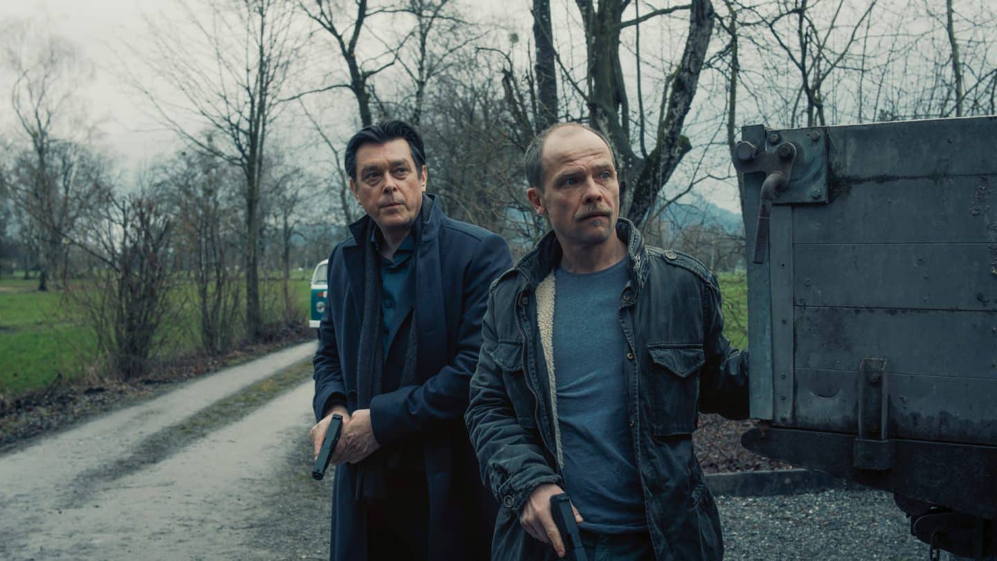 "Die Toten vom Bodensee - Die Medusa": Thomas Komlatschek (Hary Prinz) und Micha Oberländer (Matthias Koeberlin) stehen nebeneinander hinter einem Wagen. Beide haben eine Waffe in der Hand.
