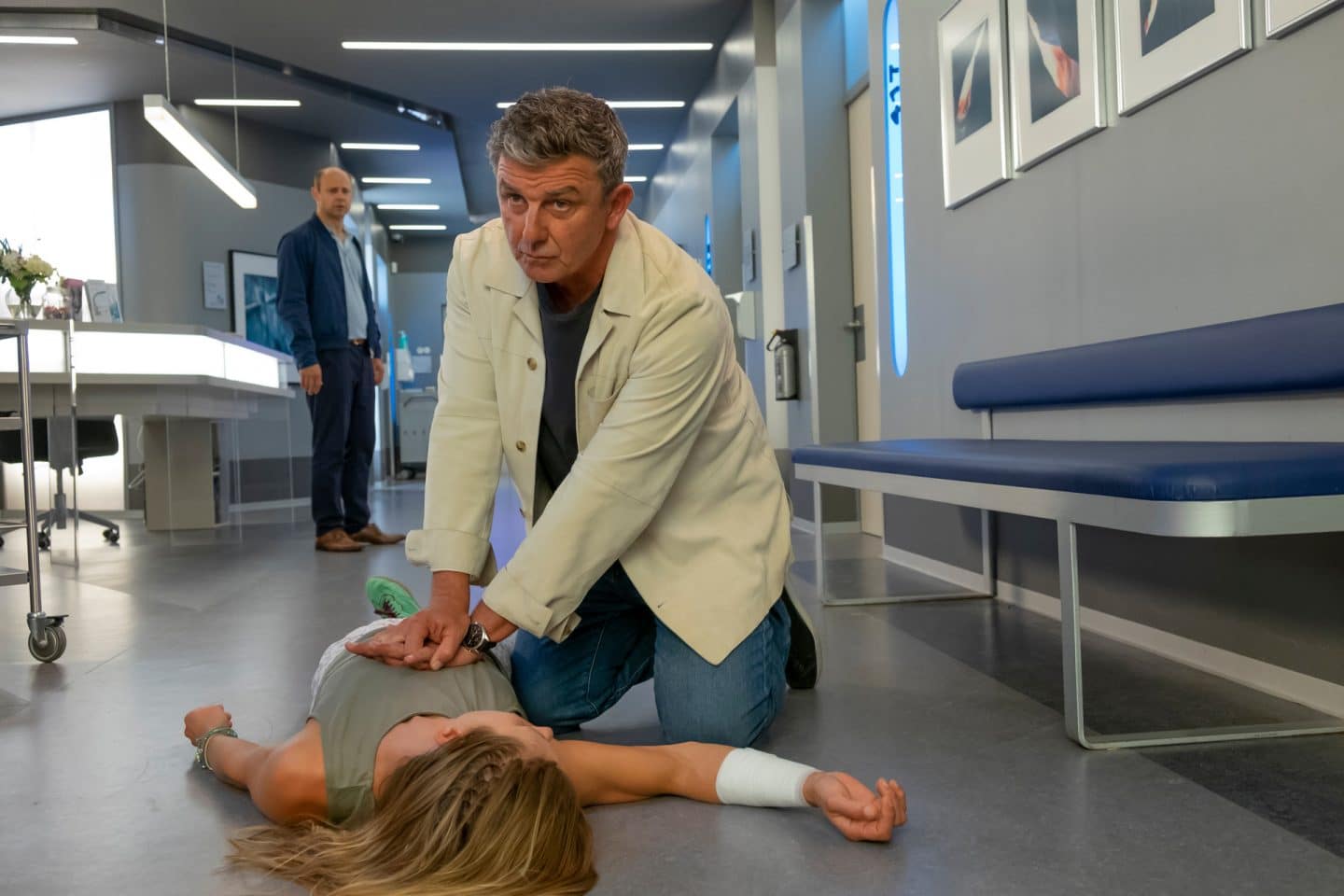 "Der Bergdoktor: Ein neuer Mensch": Im Krankenhausflur: Dr. Martin Gruber (Hans Sigl) leistet eine Herzdruck-Massage bei der am Boden liegenden Tina Reichert (Xenia Tiling). Im Hintergrund beobachtet Michi Reichert (Moritz Führmann) besorgt die Maßnahme.
