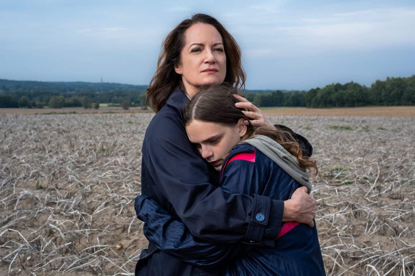 "Unter anderen Umständen – Die einzige Zeugin": Jana Winter (Natalia Wörner) stht im Feld und umarmt Lea Hansen (Mariella Aumann) .
