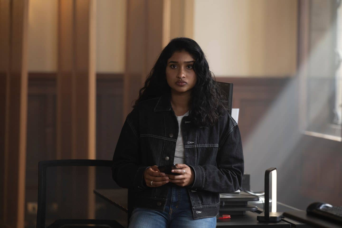 "Annika – Mord an Schottlands Küste - Comedy": DC Harper Weston (Varada Sethu) steht in einem Büro. Durch das Fenster neben ihr fällt Tageslicht in den Raum.
