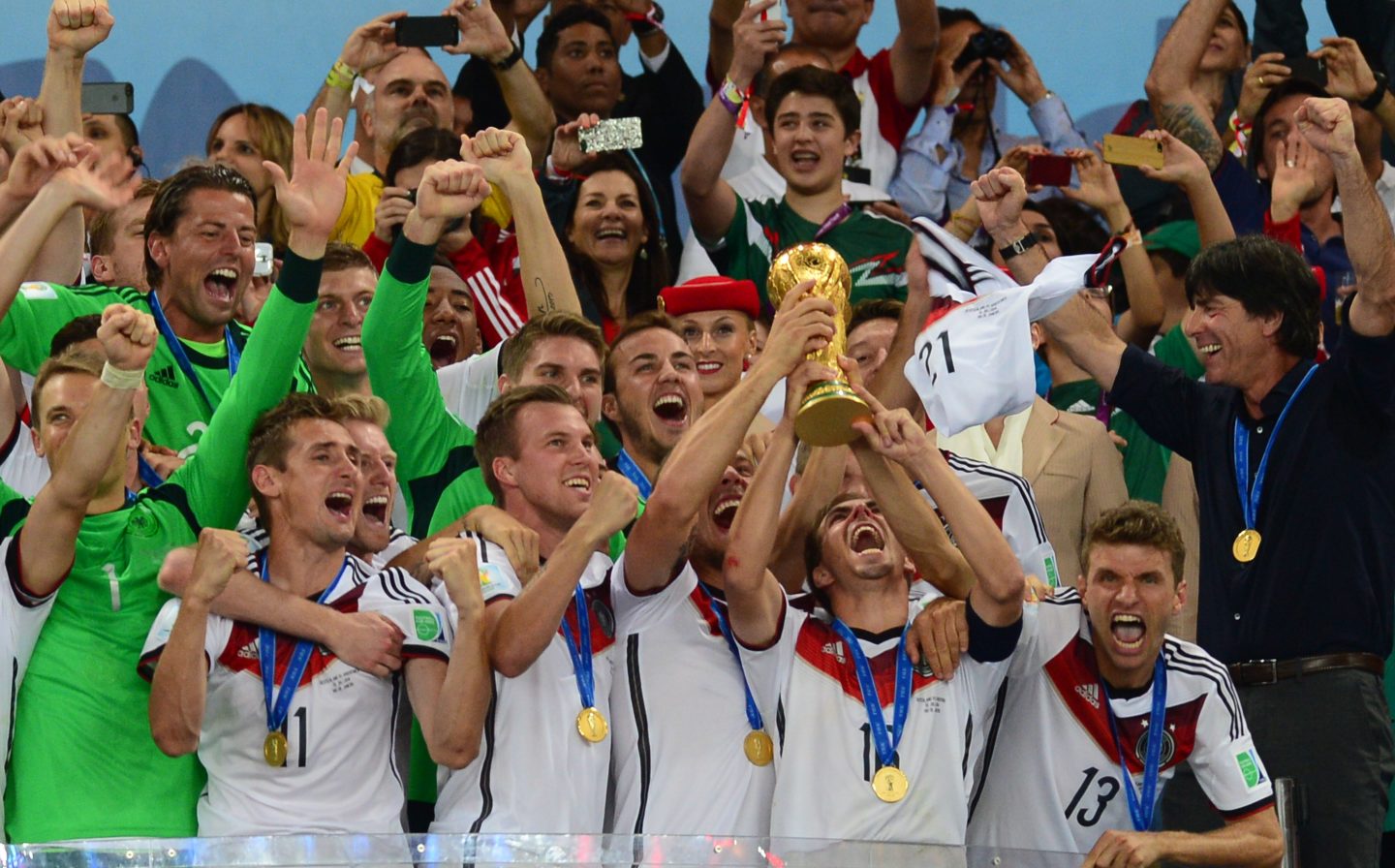 Die deutsche Nationalmannschaft feiert den WM-Sieg 2014 in Brasilien. Spieler in weißen Trikots mit Goldmedaillen jubeln, Mario Götze hebt den WM-Pokal in die Höhe, Bundestrainer Joachim Löw strahlt am rechten Bildrand.




Die deutsche Nationalmannschaft feiert den WM-Sieg 2014 in Brasilien. Spieler in weißen Trikots mit Goldmedaillen jubeln, Mario Götze hebt den WM-Pokal in die Höhe, Bundestrainer Joachim Löw strahlt am rechten Bildrand.










