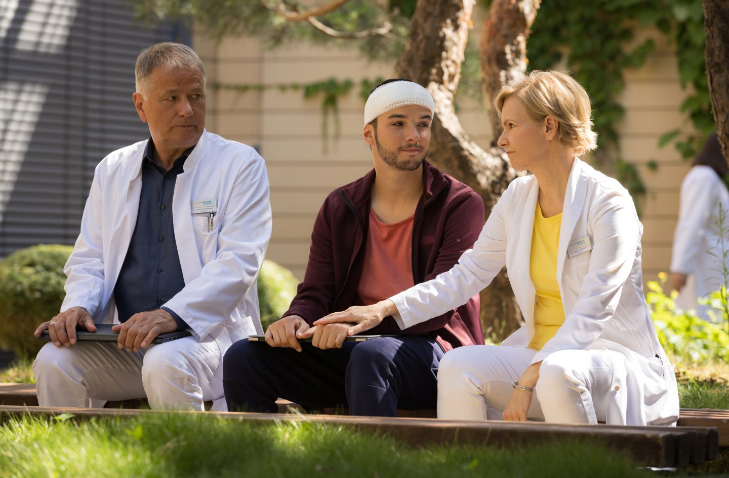 Dr. Roland Heilmann (Thomas Rühmann, li.) lässt sich von seinem Enkel Jonas (Anthony Petrifke, mi.), dem es schon viel besser geht, mit den Tondateien für seinen Podcast helfen. Doch Rolands Frau Dr. Kathrin Globisch (Andrea Kathrin Loewig, re.) ist der Meinung, dass Jonas noch etwas Ruhe braucht und unterbindet die Lehrstunde.
