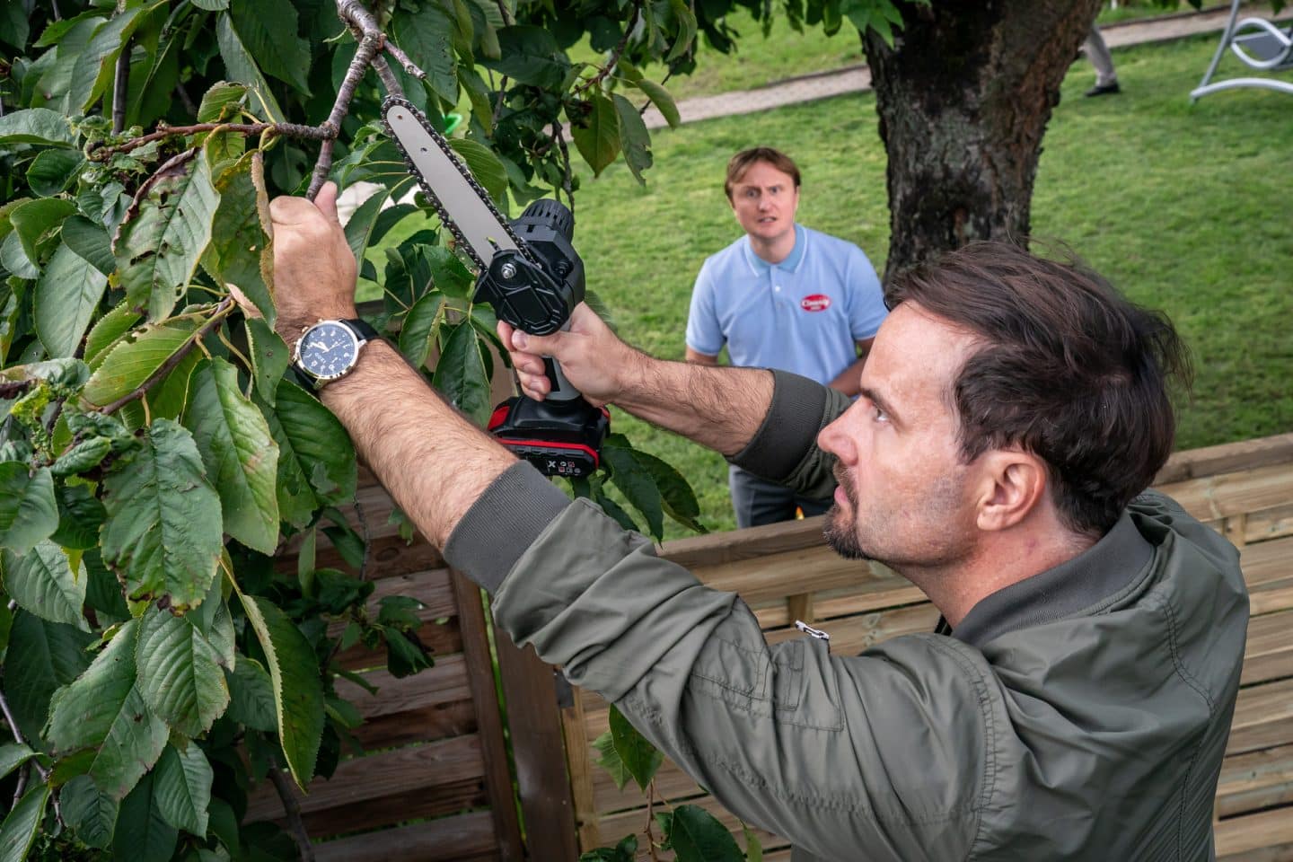 "SOKO Leipzig - Hasch mich": Jimmy Niehaus (Michael Kranz) schaut mit verzweifeltem Blick zu, wie Götz Berger (Simon Eckert) einen Zweig absägen möchte, der von einem Baum aus Jimmys Garten in seinen eigenen ragt.