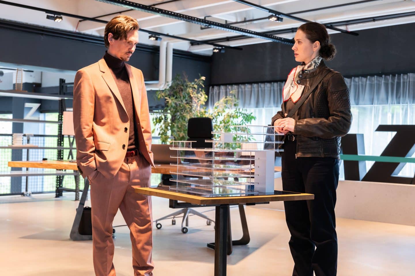 "Die Toten von Salzburg - Mord in bester Lage": Francis Zeferer (Christopher Schärf) und Irene Russmeyer (Fanny Krausz) stehen zusammen im Immobilienbüro vor einem Architekturmodell.