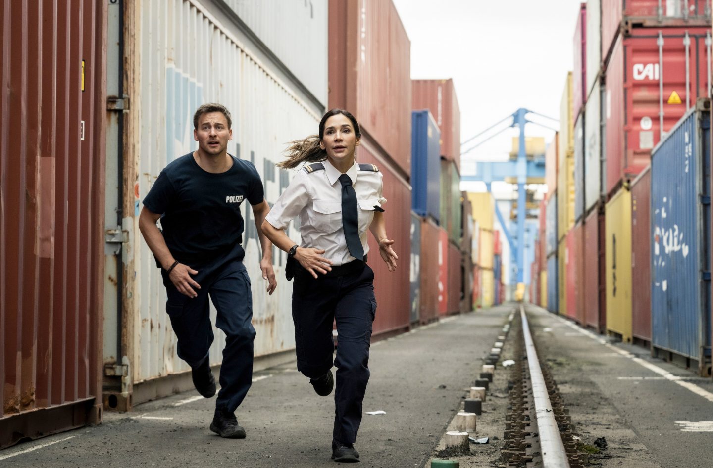 Arda (Yasemin Cetinkaya, r.) und Mark (Timmi Trinks, l.) verfolgen einen Verdächtigen, der über die Container flüchtet.